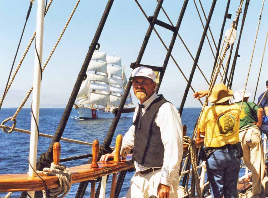 Captain Goben aboard the tallship Star of India. The tallship Eagle, a Coast Guard training vessel, ghosts along off the starboard beam.
